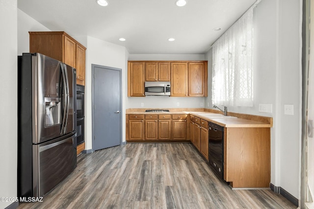 329 W Vuelta Friso, Sahuarita, AZ 85629 - kitchen with black appliances, wood finished floors, a sink, light countertops, and brown cabinets