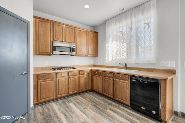 329 W Vuelta Friso, Sahuarita, AZ 85629 - kitchen featuring appliances with stainless steel finishes, a sink, brown cabinetry, light wood-style flooring, and recessed lighting