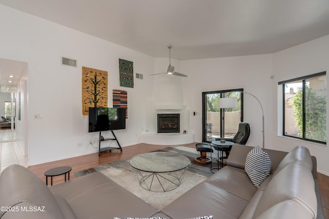 6061 N Tocito Pl, Tucson, AZ 85718 - living room with a ceiling fan, plenty of natural light, a glass covered fireplace, and wood finished floors