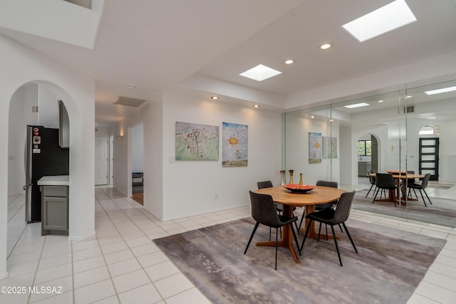 6061 N Tocito Pl, Tucson, AZ 85718 - dining area with light tile patterned floors, a skylight, arched walkways, and recessed lighting