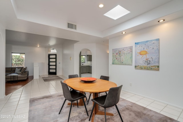 6061 N Tocito Pl, Tucson, AZ 85718 - dining space with light tile patterned floors, recessed lighting, arched walkways, a raised ceiling, and a skylight
