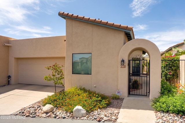 6061 N Tocito Pl, Tucson, AZ 85718 - view of front facade with stucco siding, driveway, a garage, and a gate