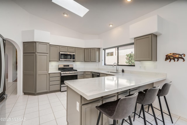6061 N Tocito Pl, Tucson, AZ 85718 - kitchen featuring appliances with stainless steel finishes, gray cabinets, a sink, a peninsula, and high vaulted ceiling
