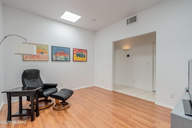6061 N Tocito Pl, Tucson, AZ 85718 - sitting room featuring a skylight, light wood-style flooring, and baseboards