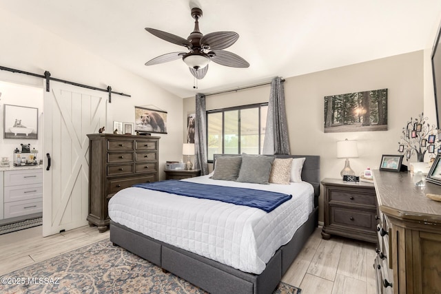 5831 N Moonbrook Rd, Tucson, AZ 85741 - bedroom with a barn door, light wood-style floors, and ceiling fan