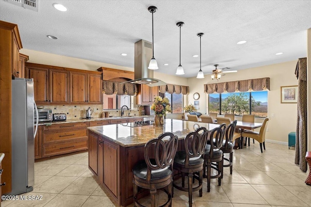 1969 W Three Oclock Hill Rd, Oracle, AZ 85623 - kitchen featuring freestanding refrigerator, brown cabinets, a kitchen island, light tile patterned floors, and recessed lighting