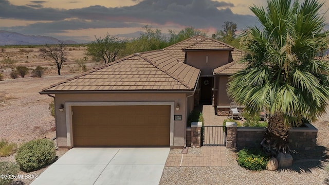 22100 E Statehood Ln, Red Rock, AZ 85145 - view of front of house with concrete driveway, a gate, a tile roof, stucco siding, and an attached garage