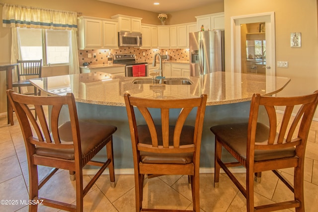 22100 E Statehood Ln, Red Rock, AZ 85145 - kitchen with appliances with stainless steel finishes, backsplash, white cabinets, light stone counters, and a kitchen breakfast bar