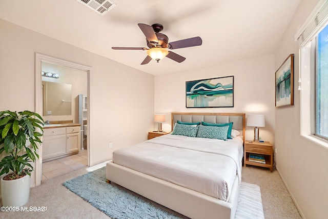 1448 N Calle Futura, Oracle, AZ 85623 - bedroom with light carpet, ensuite bathroom, a sink, ceiling fan, and baseboards