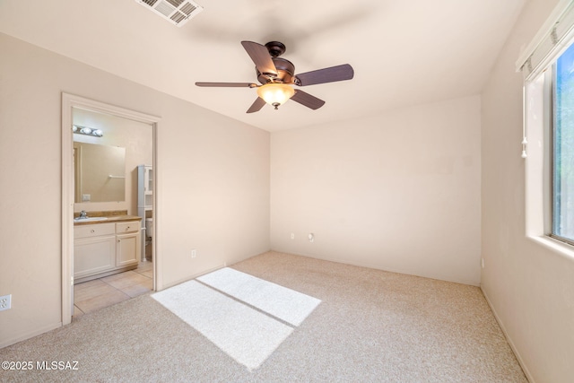 1448 N Calle Futura, Oracle, AZ 85623 - unfurnished bedroom featuring light carpet, a sink, ensuite bath, and ceiling fan