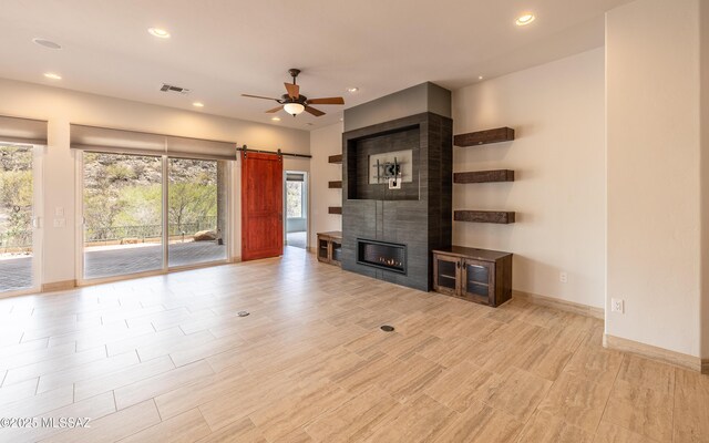 13570 N Nightstar Ct, Marana, AZ 85658 - unfurnished living room with a ceiling fan, recessed lighting, a barn door, baseboards, and a fireplace