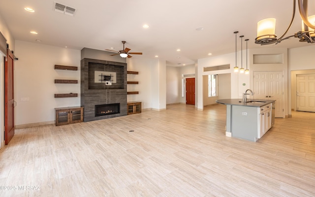 13570 N Nightstar Ct, Marana, AZ 85658 - unfurnished living room with a sink, ceiling fan, recessed lighting, a fireplace, and baseboards