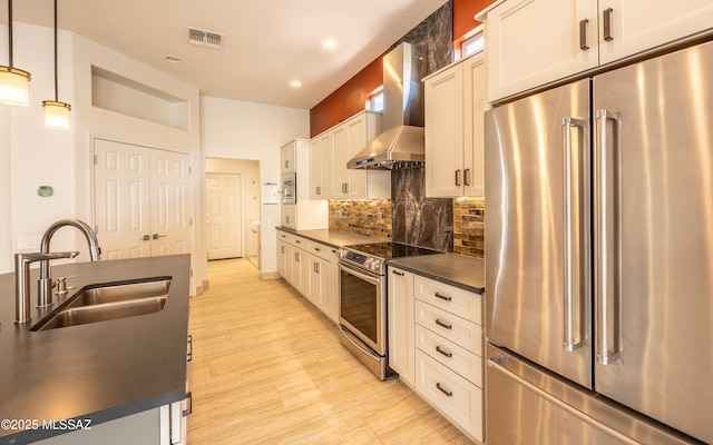 13570 N Nightstar Ct, Marana, AZ 85658 - kitchen featuring appliances with stainless steel finishes, wall chimney range hood, a sink, dark countertops, and decorative backsplash