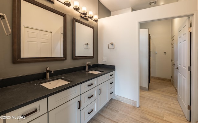 13570 N Nightstar Ct, Marana, AZ 85658 - bathroom with double vanity, wood finished floors, and baseboards