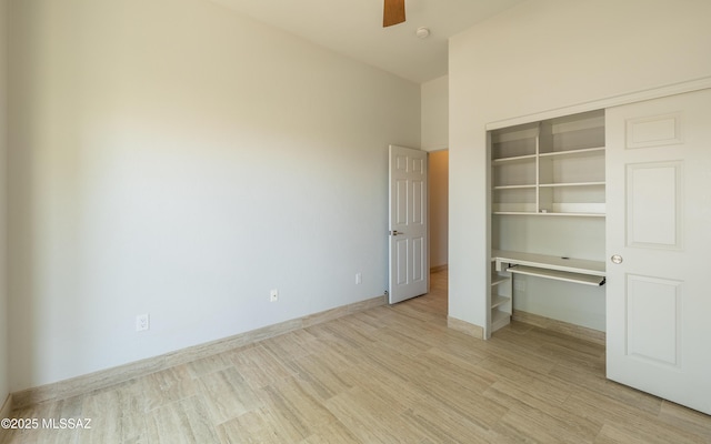 13570 N Nightstar Ct, Marana, AZ 85658 - unfurnished bedroom with light wood-style floors, a closet, a ceiling fan, a desk, and baseboards