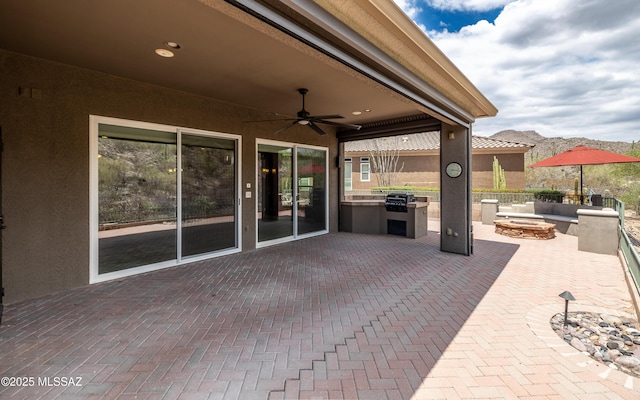 13570 N Nightstar Ct, Marana, AZ 85658 - view of patio with exterior kitchen, a ceiling fan, and an outdoor fire pit