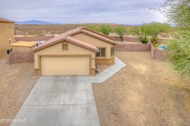 7077 S Cottontail Run Ave, Tucson, AZ 85756 - view of front of home with driveway, a mountain view, an attached garage, and stucco siding