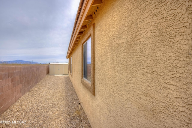 7077 S Cottontail Run Ave, Tucson, AZ 85756 - view of side of home featuring stucco siding, a fenced backyard, and a mountain view