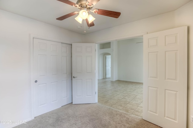 7077 S Cottontail Run Ave, Tucson, AZ 85756 - unfurnished bedroom with arched walkways, a ceiling fan, light carpet, and a closet