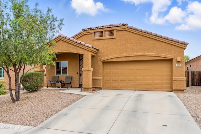 208 E Calle Trona, Green Valley, AZ 85614 - mediterranean / spanish-style home featuring concrete driveway, stucco siding, an attached garage, and a tiled roof
