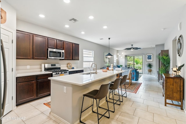 208 E Calle Trona, Green Valley, AZ 85614 - kitchen featuring stainless steel appliances, a sink, light countertops, a kitchen island with sink, and a breakfast bar area