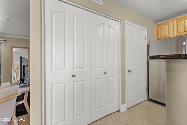 5751 N Kolb Rd Unit 23104, Tucson, AZ 85750 - kitchen with freestanding refrigerator, light tile patterned floors, light brown cabinetry, ornamental molding, and dark countertops