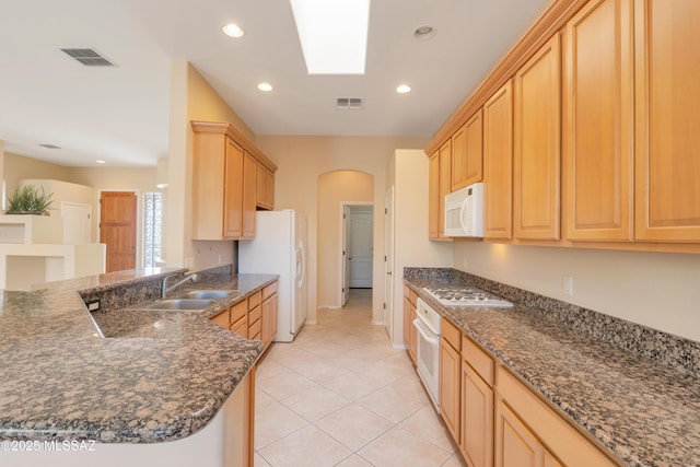6321 N Via Lomas De Paloma, Tucson, AZ 85718 - kitchen with white appliances, arched walkways, a sink, light brown cabinets, and a peninsula