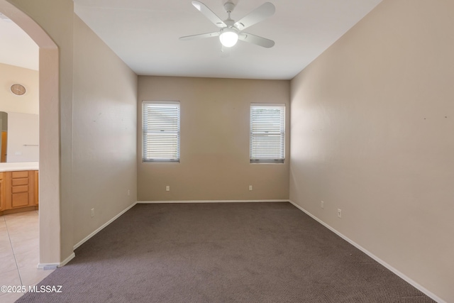6321 N Via Lomas De Paloma, Tucson, AZ 85718 - unfurnished room with arched walkways, light carpet, ceiling fan, and baseboards