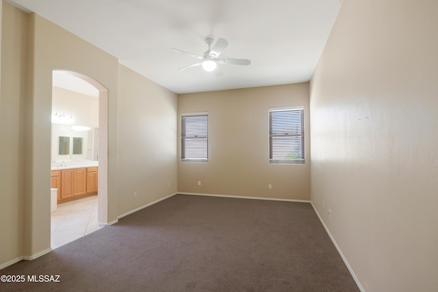 6321 N Via Lomas De Paloma, Tucson, AZ 85718 - spare room featuring light colored carpet, a ceiling fan, arched walkways, a sink, and baseboards
