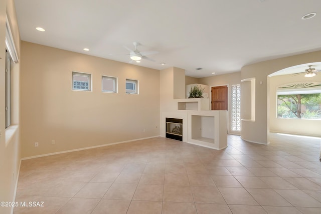 6321 N Via Lomas De Paloma, Tucson, AZ 85718 - unfurnished living room with a ceiling fan, light tile patterned floors, recessed lighting, a glass covered fireplace, and baseboards