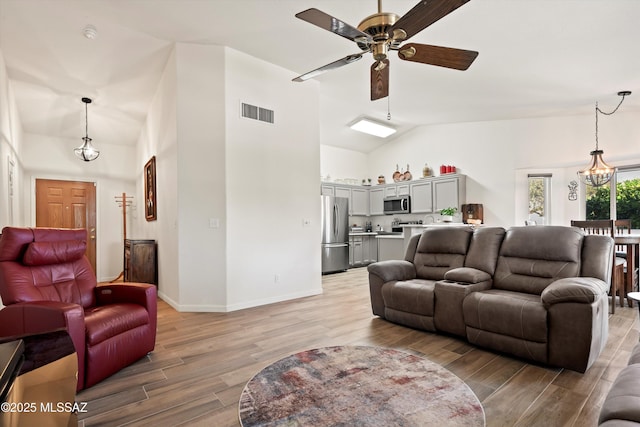 9586 E Paseo, San Bernardo, Tucson, AZ 85747 - living area featuring ceiling fan, light wood-style flooring, a chandelier, baseboards, and high vaulted ceiling