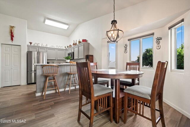 9586 E Paseo, San Bernardo, Tucson, AZ 85747 - dining room featuring a chandelier, baseboards, light wood-type flooring, and vaulted ceiling