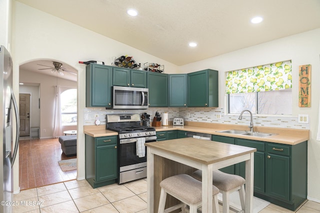3521 W Camino De Talia, Tucson, AZ 85741 - kitchen featuring stainless steel appliances, green cabinetry, a sink, vaulted ceiling, and decorative backsplash