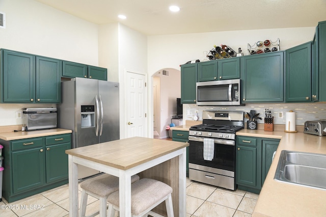 3521 W Camino De Talia, Tucson, AZ 85741 - kitchen featuring stainless steel appliances, light tile patterned floors, arched walkways, light countertops, and recessed lighting