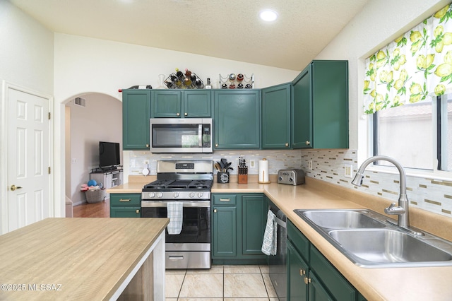 3521 W Camino De Talia, Tucson, AZ 85741 - kitchen featuring stainless steel appliances, a sink, vaulted ceiling, light countertops, and decorative backsplash