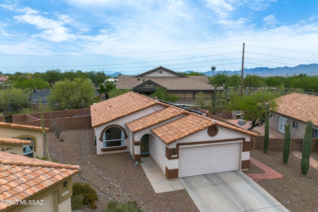 3521 W Camino De Talia, Tucson, AZ 85741 - mediterranean / spanish house with an attached garage, concrete driveway, a tiled roof, stucco siding, and a mountain view