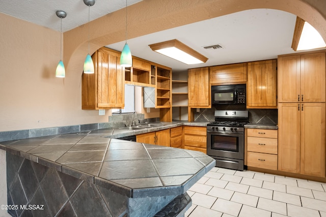 908 E Weymouth St, Tucson, AZ 85719 - kitchen with stainless steel gas stove, black microwave, a sink, open shelves, and a peninsula