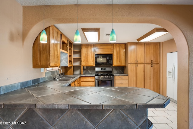 908 E Weymouth St, Tucson, AZ 85719 - kitchen featuring gas range, black microwave, a sink, a peninsula, and white fridge with ice dispenser