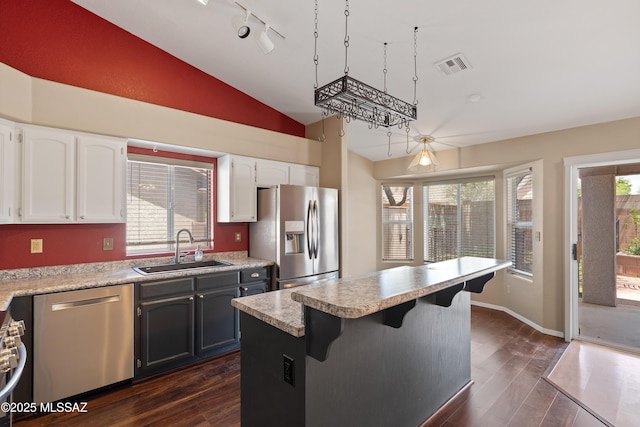 9510 E Danforth Pl, Tucson, AZ 85747 - kitchen with appliances with stainless steel finishes, a sink, lofted ceiling, white cabinets, and dark wood finished floors