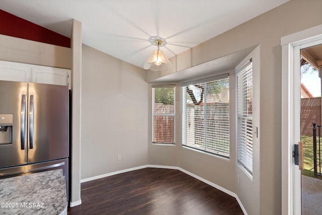 9510 E Danforth Pl, Tucson, AZ 85747 - unfurnished dining area with dark wood-style floors, healthy amount of natural light, and baseboards