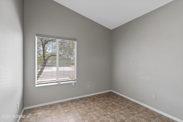 9510 E Danforth Pl, Tucson, AZ 85747 - spare room with baseboards, lofted ceiling, and stone finish flooring