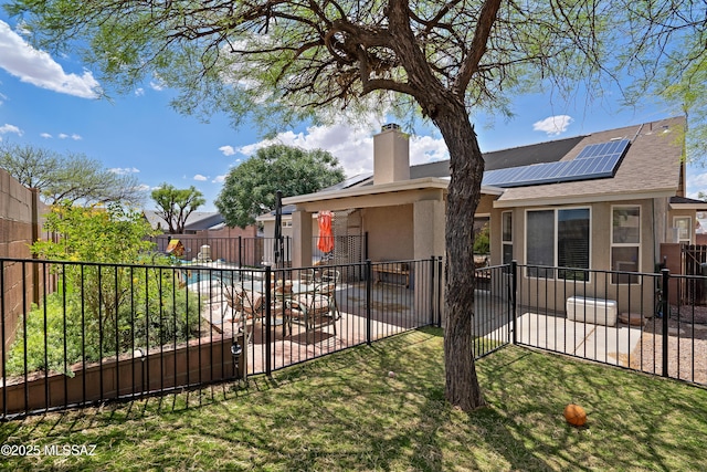 9510 E Danforth Pl, Tucson, AZ 85747 - view of front of house with stucco siding, solar panels, a patio area, and a chimney