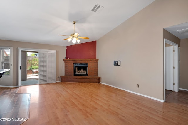 9510 E Danforth Pl, Tucson, AZ 85747 - unfurnished living room featuring a ceiling fan, light wood-style floors, a fireplace, baseboards, and lofted ceiling