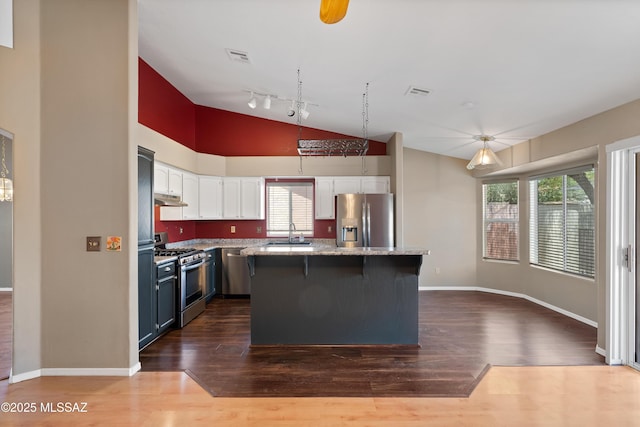 9510 E Danforth Pl, Tucson, AZ 85747 - kitchen featuring stainless steel appliances, white cabinets, a sink, dark wood-type flooring, and a kitchen island