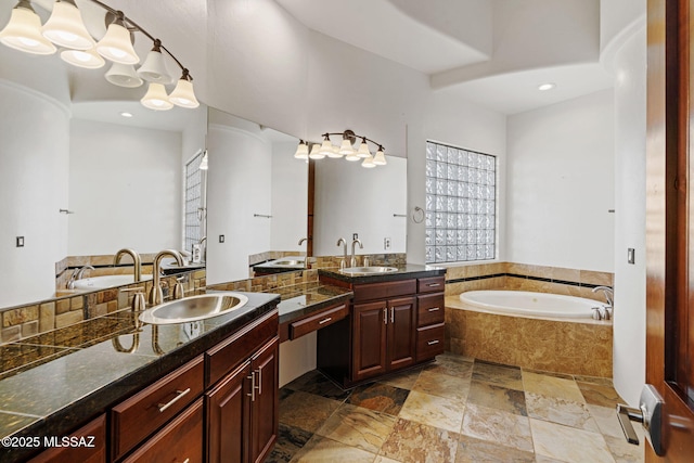 8505 S Circle C Ranch Rd, Vail, AZ 85641 - bathroom with a bath, two vanities, stone tile floors, and recessed lighting