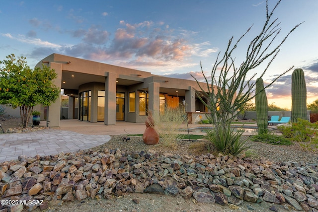 8505 S Circle C Ranch Rd, Vail, AZ 85641 - back of house at dusk with stucco siding and a patio
