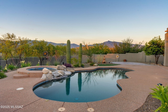 8505 S Circle C Ranch Rd, Vail, AZ 85641 - pool at dusk with an in-ground hot tub, a mountain view, and a fenced backyard