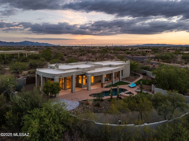 8505 S Circle C Ranch Rd, Vail, AZ 85641 - back of house at dusk with a fenced backyard, a mountain view, a patio, stucco siding, and an outdoor pool
