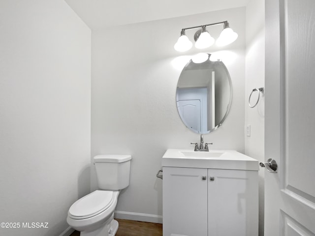 7637 E Cholla Overlook Dr, Tucson, AZ 85710 - half bath featuring vanity, toilet, baseboards, and wood finished floors