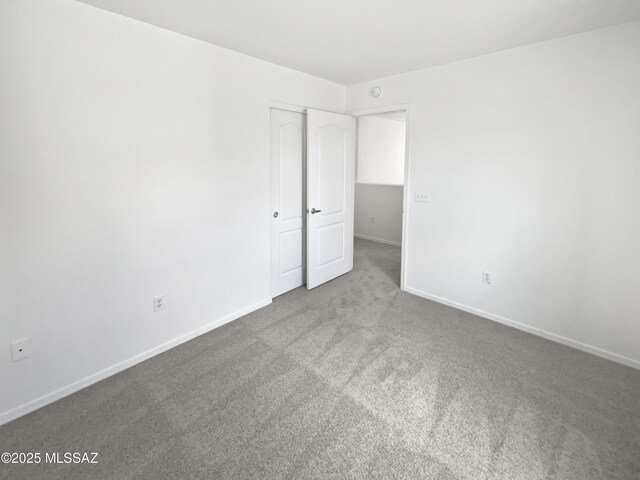 7637 E Cholla Overlook Dr, Tucson, AZ 85710 - unfurnished bedroom featuring carpet, baseboards, and a closet